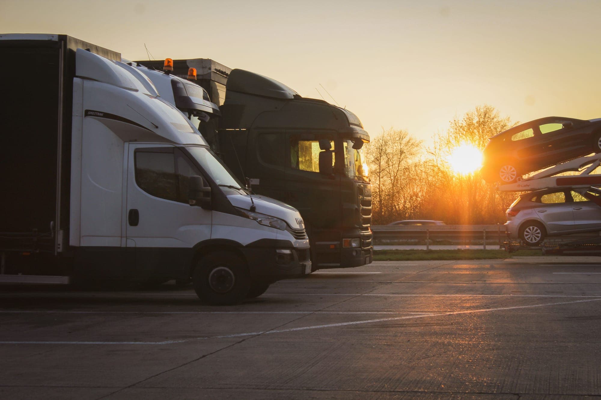 Camioane și o dubă de transport parcate la răsărit